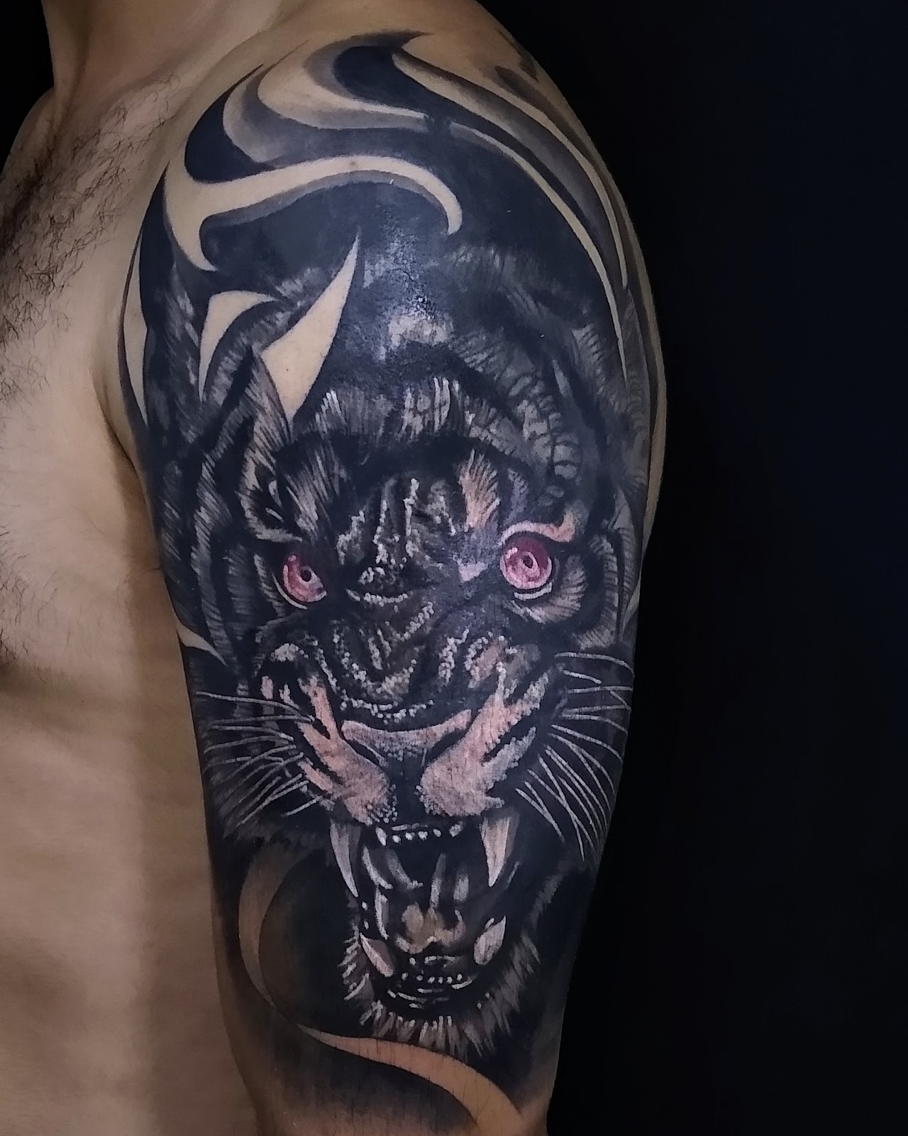 Tatuaje blackwork de felino en brazo